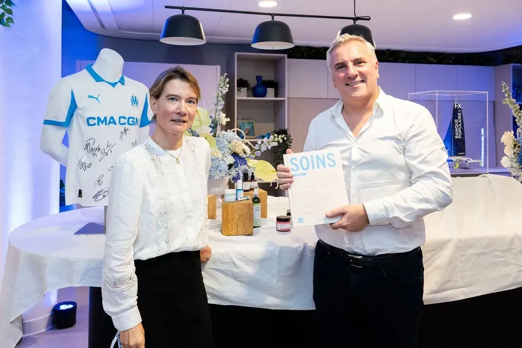 Remise du livre « Soins » devant le maillot de l’Olympique de Marseille dédicacé et les produits Aroma-Zone mis en tombola.