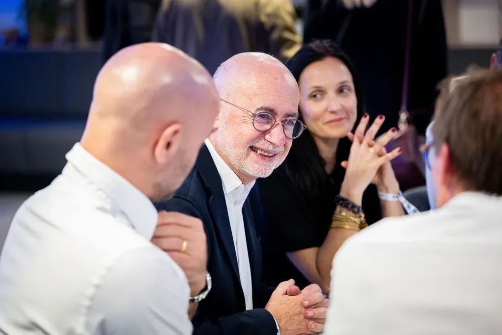 Des convives échangent autour d’une table pendant la soirée.