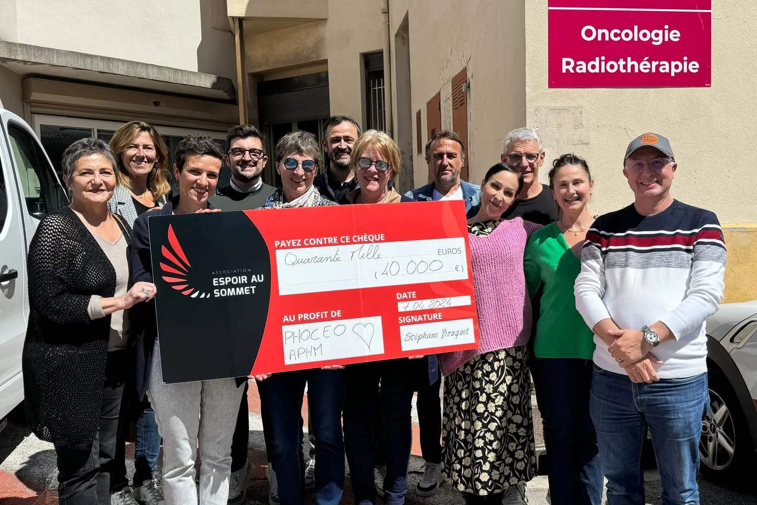 Devant le service d’oncologie-radiothérapie de l’AP-HM, une quinzaine de personnes entourent le chèque de 40 000 € d’Espoir au sommet.