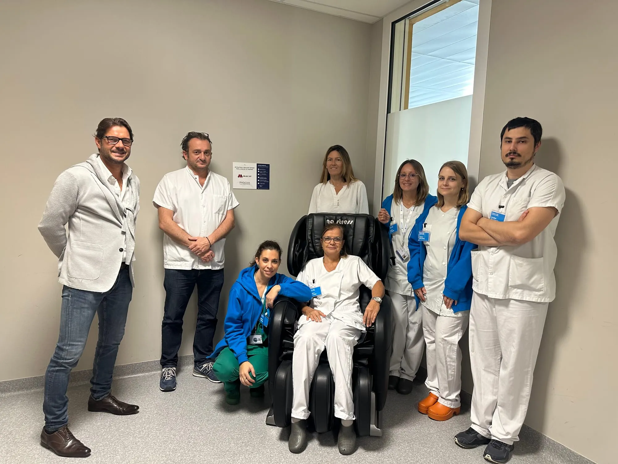 Une équipe soignante réunie autour d’un fauteuil de massage installé dans le service.