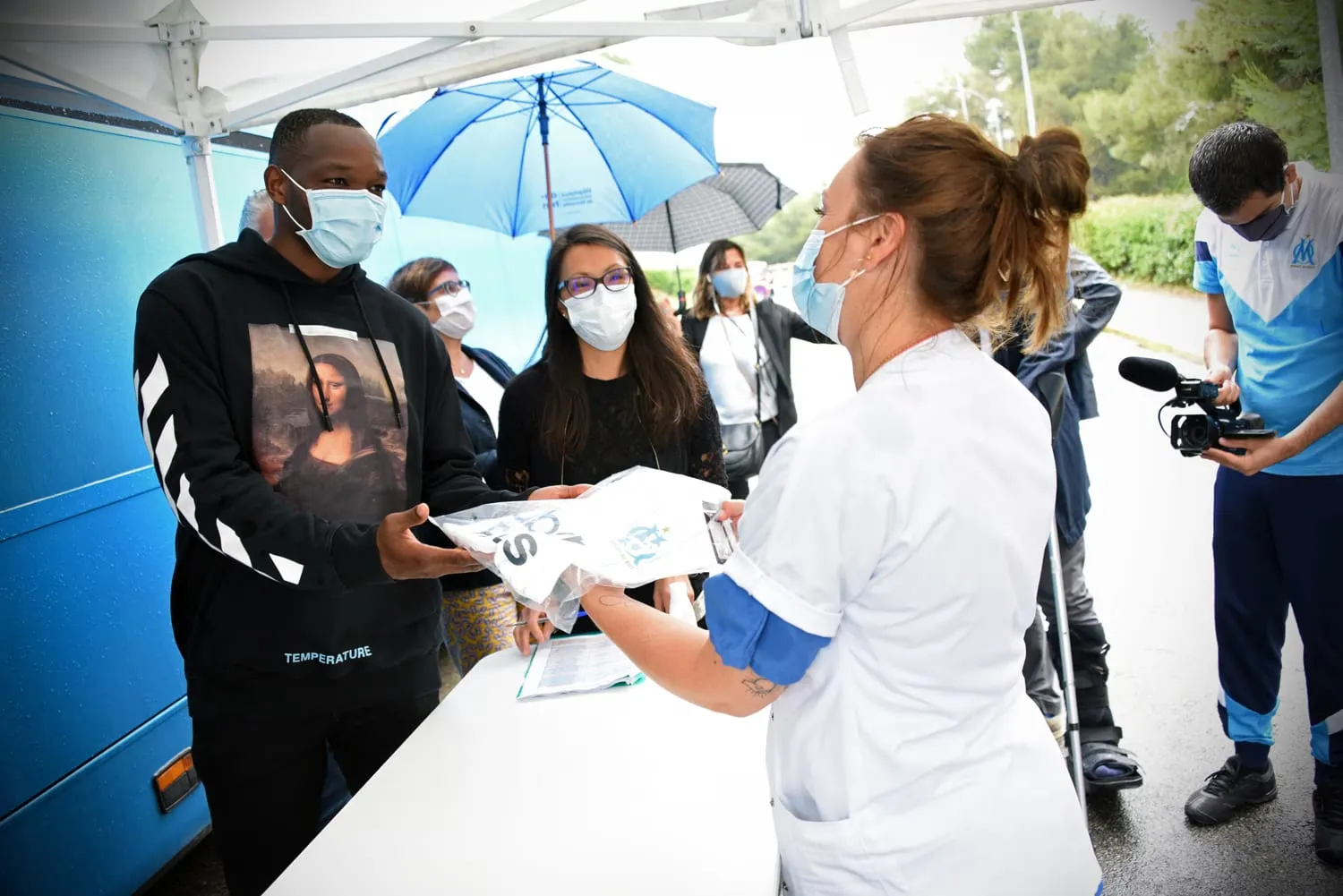Un joueur de l’Olympique de Marseille signe des autographes pour les équipes hospitalières.