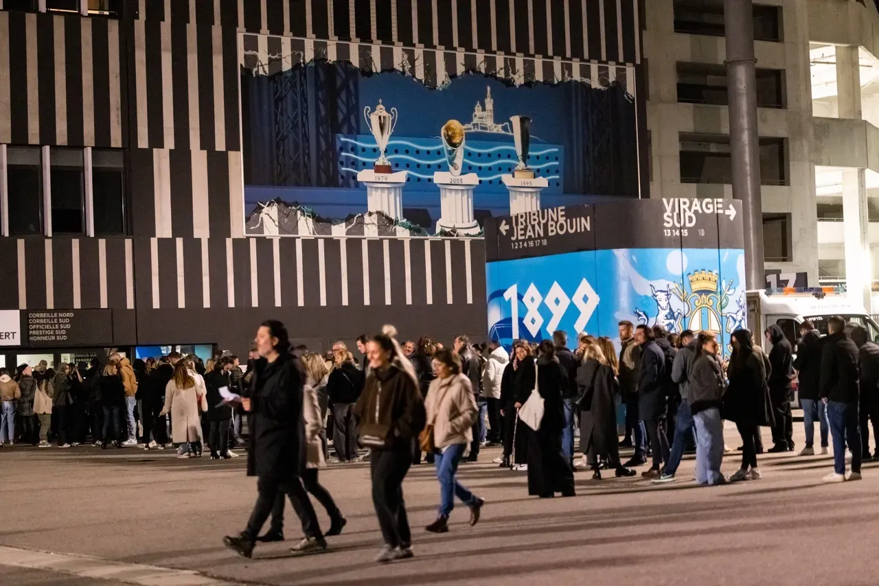 Le parvis du stade avant la soirée, devant la fresque des trophées et le blason « 1899 ».